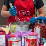 A volunteer using a mixing bowl, surrounded by baking ingredients