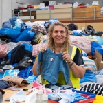 A corporate volunteer holding up a donation at the Save the Children warehouse