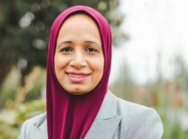 Woman named Jawaria in a maroon headdress smiling