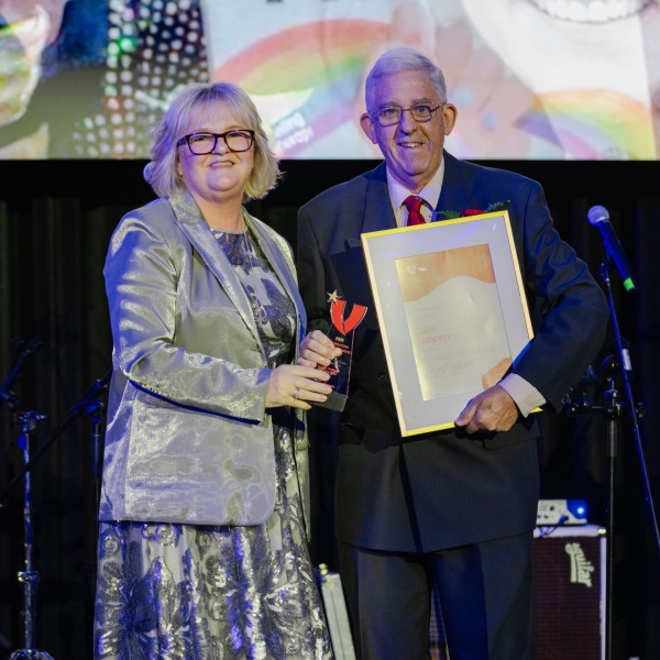 2025 Lifetime Contribution to Volunteering Award Recipient, Colin Longworth, receiving his award onstage