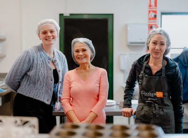 Three volunteers from People Who Care helping out with food preparation