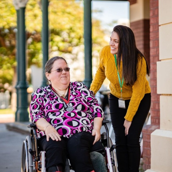 A volunteer assisting an individual in a wheelchair