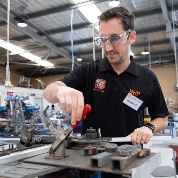 A volunteer using tools in a factory