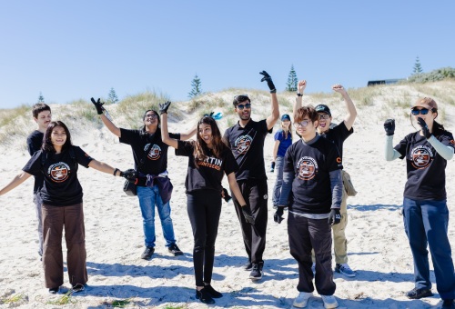 A group of people on a beach with their arms in the air