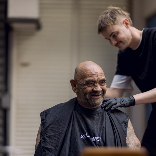 A man giving a haircut to another man
