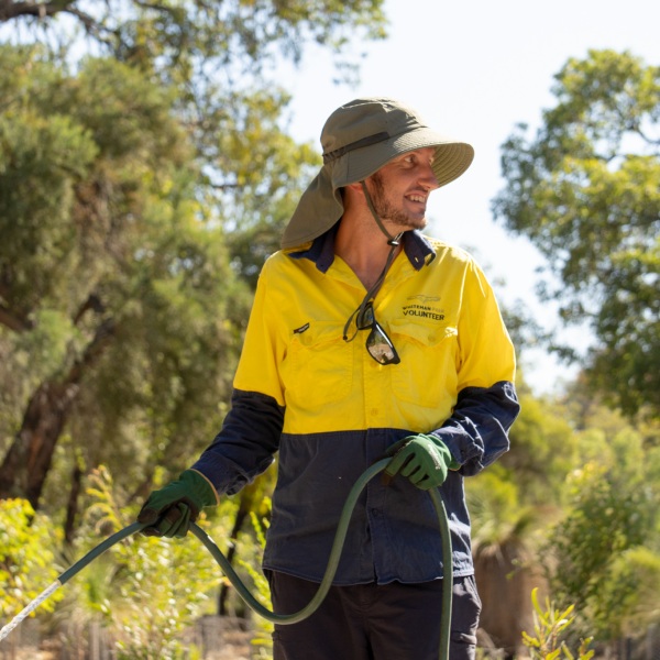 A man watering plants in a park