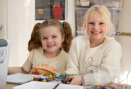 Two young volunteers sorting stationery donations for kids in need