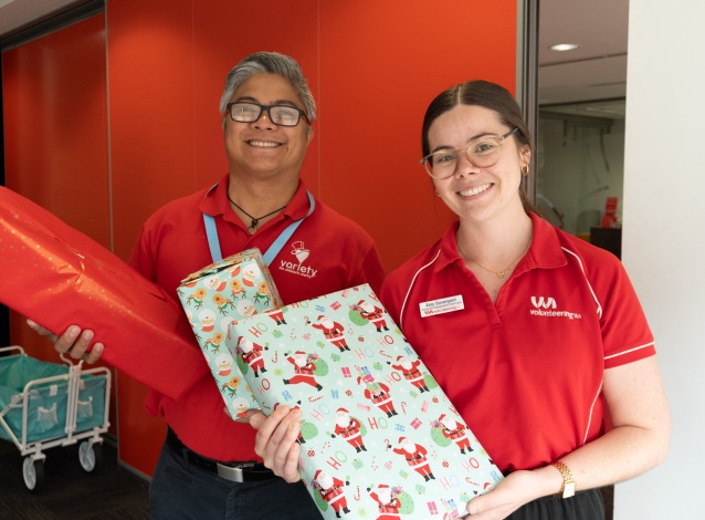 A man and woman holding up wrapped Christmas presents